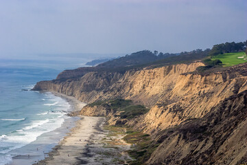 A rocky shoreline with a beach and a cliff