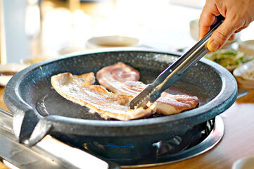 바베큐 그릴 위에서 삼겹살을 굽고 있는 모습