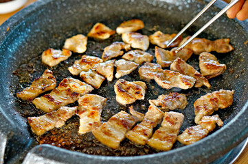 불판 위에서 삼겹살을 맛있게 굽고 있는 모습