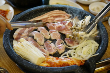 불판 위에서 삼겹살을 맛있게 굽고 있는 모습