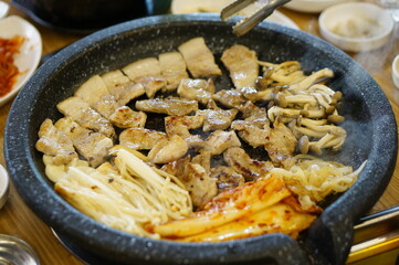 불판 위에서 삼겹살을 맛있게 굽고 있는 모습