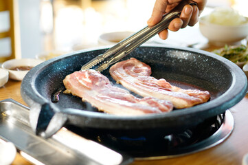 불판 위에서 삼겹살을 맛있게 굽고 있는 모습