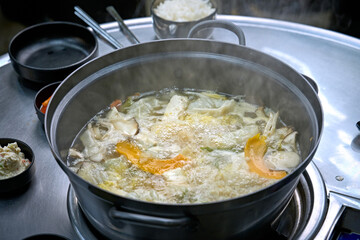 식탁 위에 만두 전골이 끓고 있는 모습