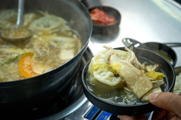 식탁 위에서 만둣국을 맛있게 끊이고 있는 모습