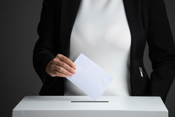 The voter holds his vote ballot paper and places it in the ballot box. Election concept.