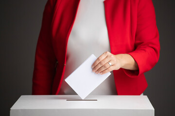 The voter holds his vote ballot paper and places it in the ballot box. Election concept.