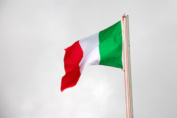 Italy flag waving on grey sky