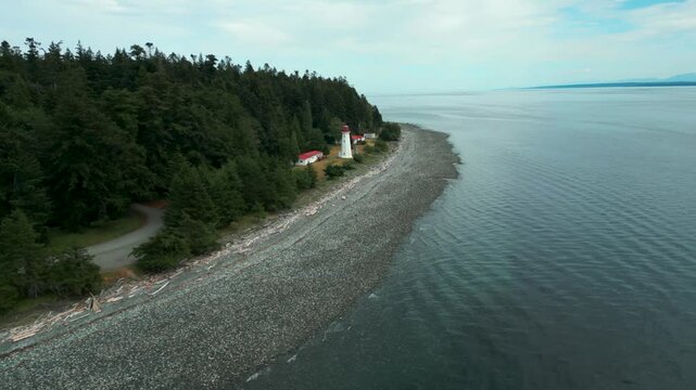 aerial shot revealing cape mudge lighthouse on Quadra Island near Vancouver Island on a cloudy day, British Columbia, Canada