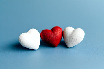 Obraz premium A few scattered hearts in red and white on a solid background creating a simple yet romantic Valentines Day design