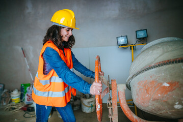  Woman working with a concrete mixer.