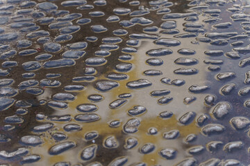 photographic background of a cobblestone floor with water and sun reflections
