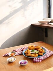 Crispy Onion Rings with Dipping Sauce on a Wooden Table