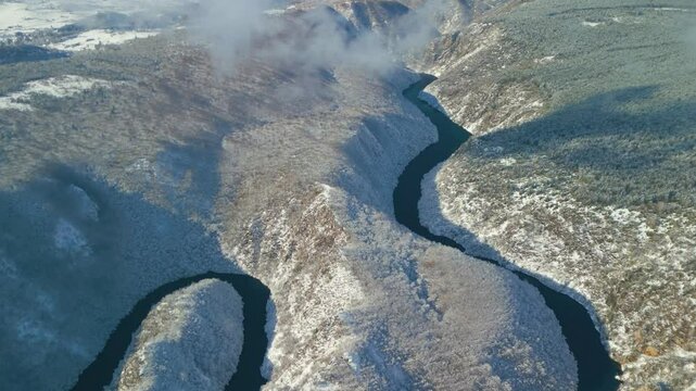 Blue river of Uvac canyon in Serbia in winter - aerial view.