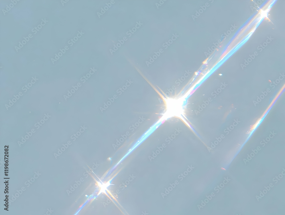 Poster light refracts through glass creating a spectrum of colors and radiant beams on a soft blue backgrou