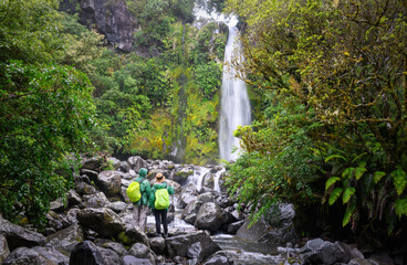 Couple enjoying the view of Dawson Falls in the rain. Egmont National Park. Taranaki.