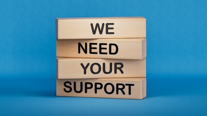 We need your support symbol. Wooden blocks with words We need your support.Business and We need...