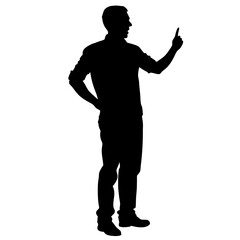 A man is standing in front of a white background. He is wearing a black shirt and black pants. He is holding a finger up in the air