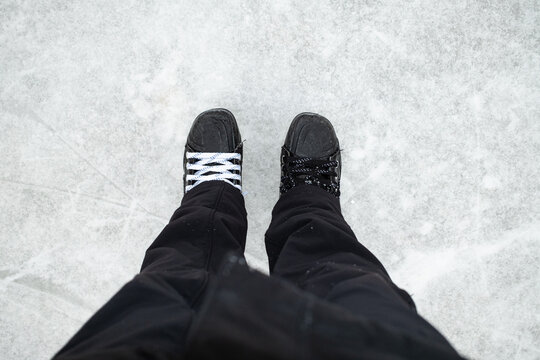 Close-up of ice skates with mismatched laces on an ice rink surf