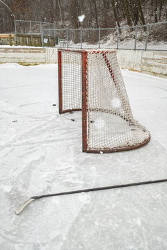 Hockey Goal and Stick on Snowy Outdoor Rink