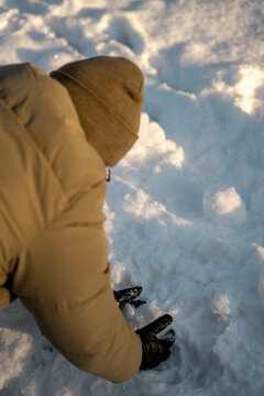 Man forming a snowball with black gloves in Oslo