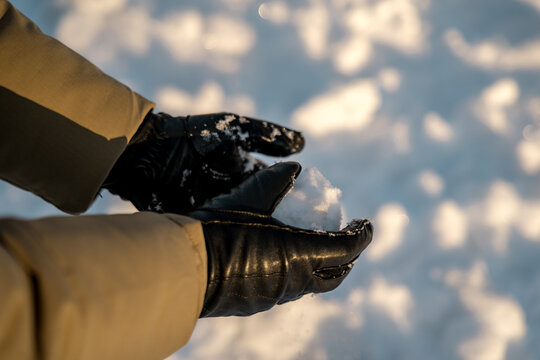 Man forming a snowball with black gloves in Oslo
