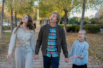 Family looking up walking in the park holding hands