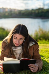 Free time and relaxation: quiet reading on the lawn of a park