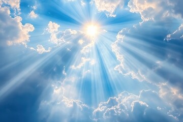 A bright sun shines through fluffy white clouds in a blue sky, creating a dramatic effect with sun rays.
