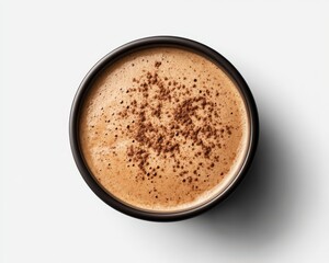 Overhead close-up of a cup of cappuccino with cinnamon sprinkled on top, set against a white background.