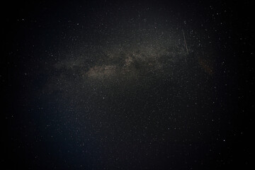 A mesmerizing view of a star-filled night sky with the Milky Way and a faint shooting star...
