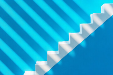 Obraz premium A section of white stairs with striking shadows on a textured, bright blue background. The interplay of light and color creates a minimalist aesthetic for design inspiration.