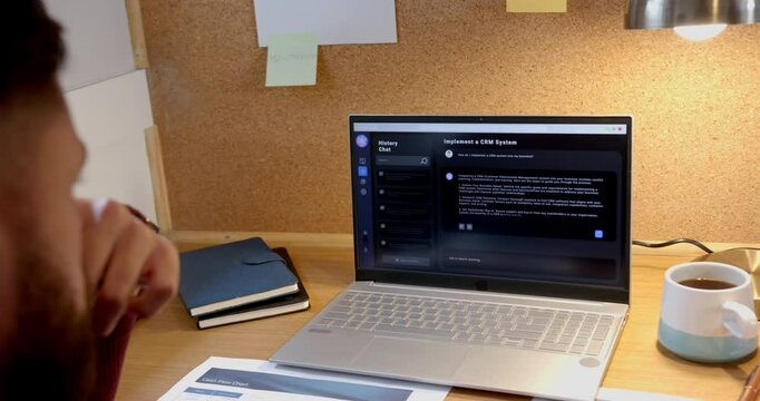 Working from home, man using laptop for online AI chatbot and project planning