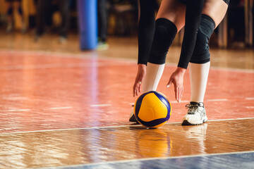 Naklejka premium Volleyball Player Reaching for Yellow Ball on Indoor Court — Moment of Action in Team Game