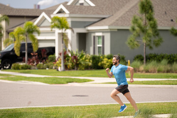 Running man sprinting workout outdoor. Fit athlete man running on american neighborhood. Sporty fit caucasian male, fitness sport model working out outside in full length.
