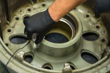 Aircraft Wheel NDT Inspection Using Ultrasonic Testing Equipment. Aviation maintenance technician performs non-destructive testing of landing gear component
