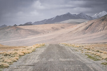 Asphalt road of the Pamir Highway in the valley of the Tien Shan Mountains in Tajikistan in the...