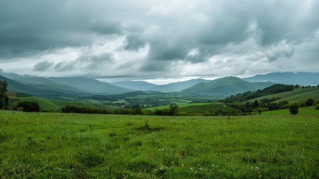 Scenic view of green hills and mountains under cloudy sky. - Powered by Adobe
