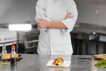 Female chef preparing vegetable salad in the kitchen
