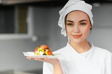 Female chef in kitchen. Cooking concept