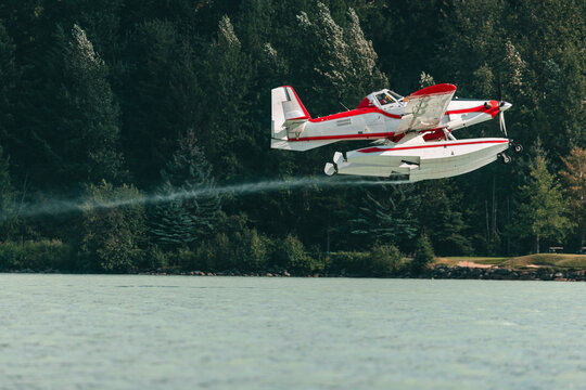 Water plane takes off from a lake, ready to fight nearby fire