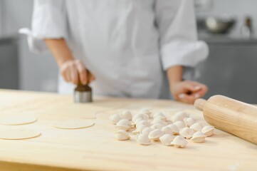 Kitchen worker makes dumplings from minced dough