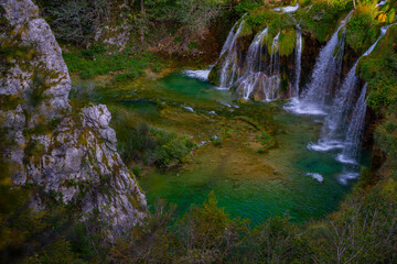 The waterfalls in forest. Summer view of beautiful waterfalls and clear lake. Plitvice Lakes National Park, Croatia. Summer nature landscape.