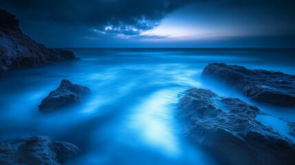 Naklejka premium Serene Blue Waters and Silhouetted Rocks at Twilight