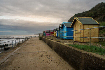 Dark clouds over the beach huts on Overstrand Beach, Norfolk, England, UK