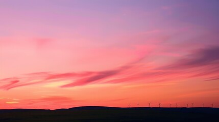 Fototapeta premium Scenic sunset view of windmills against colorful sky horizon