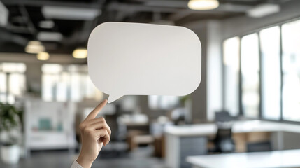 A person holding up an empty speech bubble against modern office.