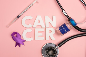 A vaccine vial and medical tools lay near the word cancer and a purple ribbon. World cancer day concept background