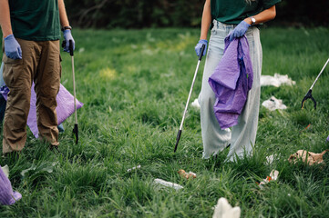 Volunteers collecting garbage with trash grabbers in park