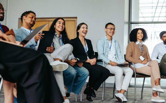 Joyful team in an office setting networking and smiling during a casual meeting - Powered by Adobe