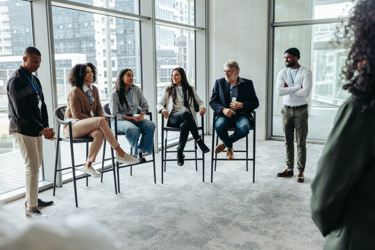 Diverse professionals engaging in a panel discussion at a corporate event, sharing insights and expertise in a modern conference room setting. - Powered by Adobe